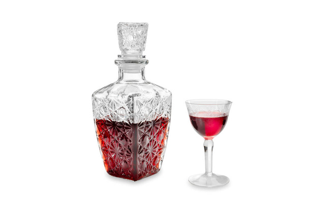 Rode kersenlikeur in glazen fles versierd met vintage glas met decoratieve gravures geïsoleerd op wit, clipping pad - Foto, afbeelding