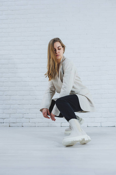 Foto de uma jovem mulher de botas brancas e roupas casuais. Nova coleção de sapatos de inverno feminino feitos de couro genuíno. - Foto, Imagem