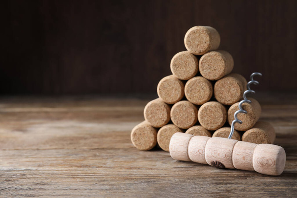 Corkscrew and wine corks on wooden table. Space for text - Photo, Image