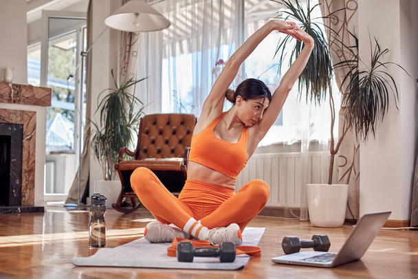 Pretty woman working out at home. Adult lady with beautiful shaped body exercising in the apartment. - Foto, Imagem