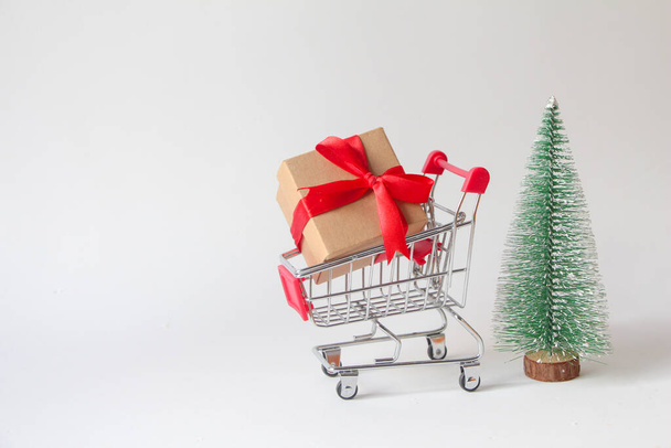 Gift box with miniature shopping cart on white background. - Photo, Image