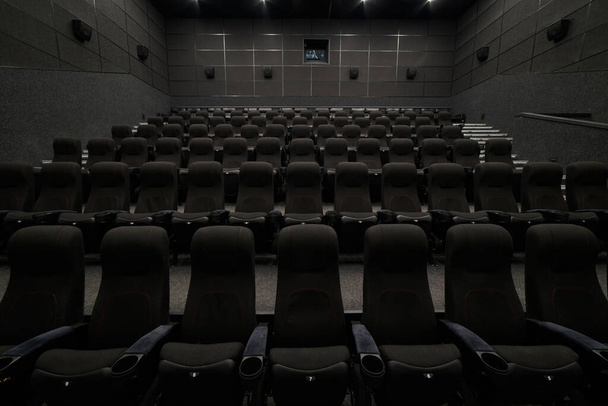 Empty cinema hall with black seats and walls. Movie theatre nobody - Zdjęcie, obraz