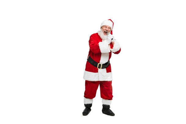 白い背景に隔離されたマイクで歌うサンタクロースのイメージのシニア男の肖像画。パーティーの時間だ。架空の人物、休日、新年、クリスマスの概念。広告のコピースペース - 写真・画像