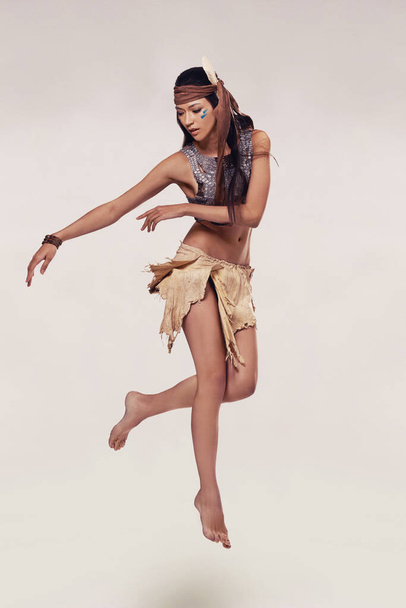 Honoring her heritage through dance. A sultry young woman in native american-inspired clothing - Φωτογραφία, εικόνα