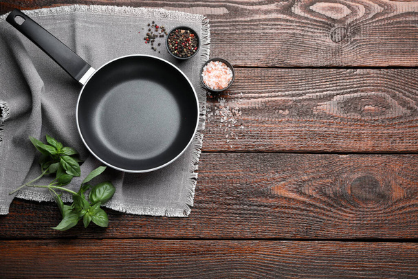 Flat lay composition with frying pan and fresh products on wooden table, space for text - Photo, image