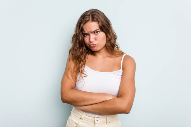 Young caucasian woman isolated on blue background unhappy looking in camera with sarcastic expression. - Фото, зображення