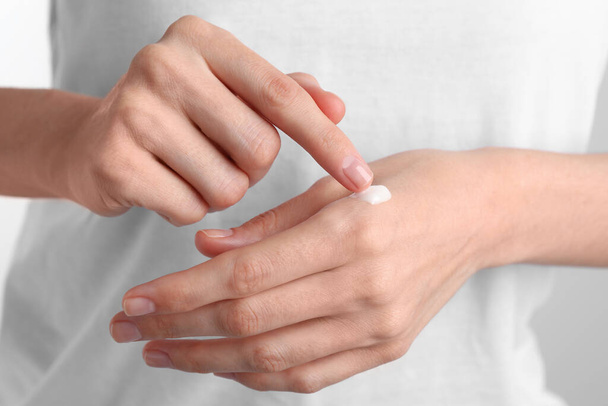 Woman applying cream onto hand, closeup view - Foto, afbeelding