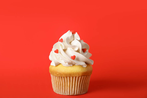 Tasty cupcake for Valentine's Day on red background - Foto, afbeelding