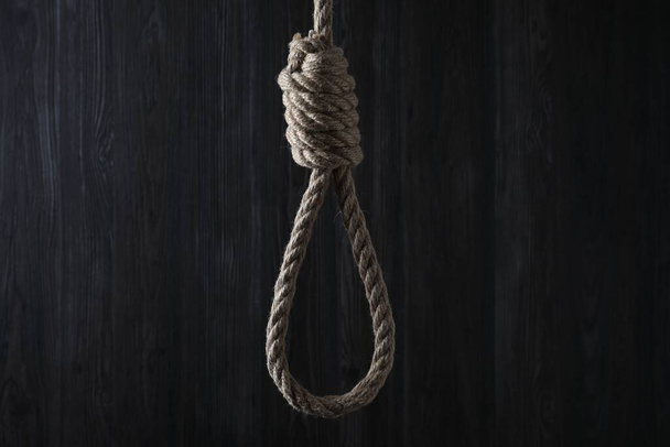 Tied rope noose against dark wooden background - Photo, Image