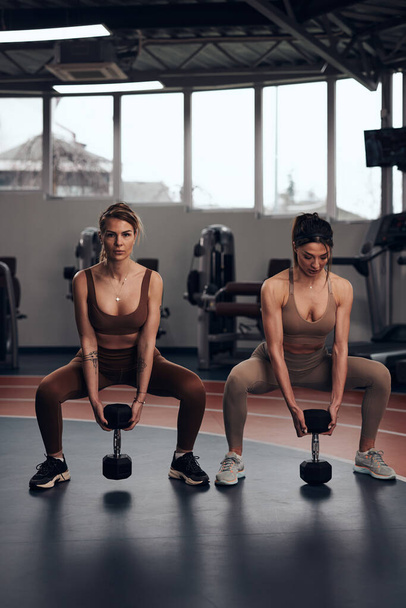 Hübsche Frauen beim Training in einem Fitnessstudio. Erwachsene Damen mit schön geformten Körpern. - Foto, Bild
