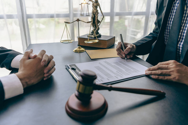 Businessman and lawyer discussing contract documents with golden scales, god of justice, yellow on wooden table in law office, advice, justice concept - Foto, Imagen