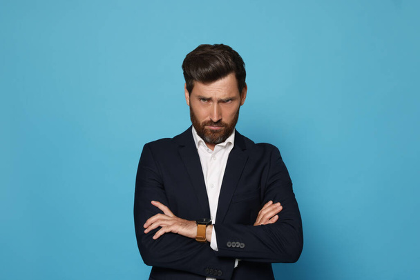 Portrait of offended bearded man on light blue background. Space for text - Foto, immagini