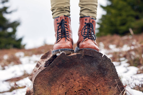 Femme en bottes en cuir debout dans la nature en saison hivernale. - Photo, image