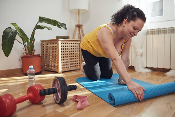 Mujer entrenando dentro de la sala de estar, haciendo ejercicio en casa. - Foto, imagen
