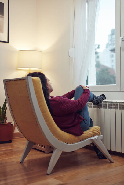 Woman heating feet on a chilly winter day, energy and gas crisis, cold room, heating problems. - Fotoğraf, Görsel