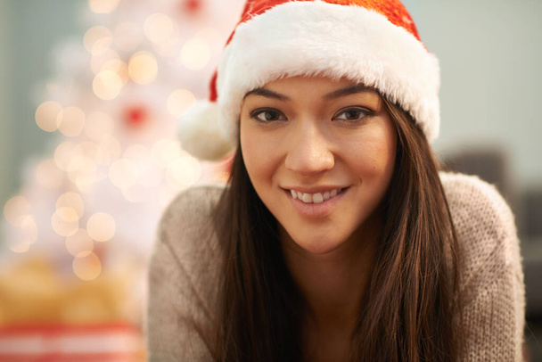 Elle a l'air joyeuse à Noël. Portrait d'une jolie jeune femme portant un chapeau de Père Noël à Noël - Photo, image