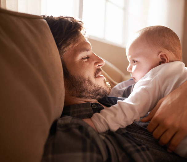 Cuddling with a cutie. an affectionate father bonding with his baby girl at home - Foto, afbeelding