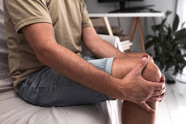 Ενήλικες άνδρες με πόνο στο γόνατο, εξάρθρωση, μούδιασμα, κράμπες και άλλα προβλήματα στις αρθρώσεις. - Φωτογραφία, εικόνα