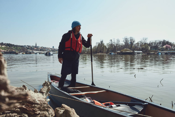Homem remando em uma canoa em um rio Danúbio na área urbana, pequena fuga recreativa, passatempos e esportes ao ar livre. - Foto, Imagem
