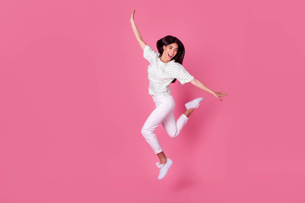 Full length photo of young attractive japanese girl jumping smile outfit poster wear trendy white clothes isolated on pink color background. - Фото, зображення