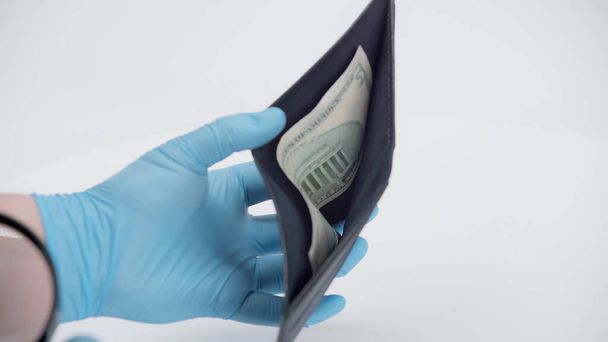 cropped view of person in latex gloves showing wallet with dollar banknote on white background  - Foto, immagini