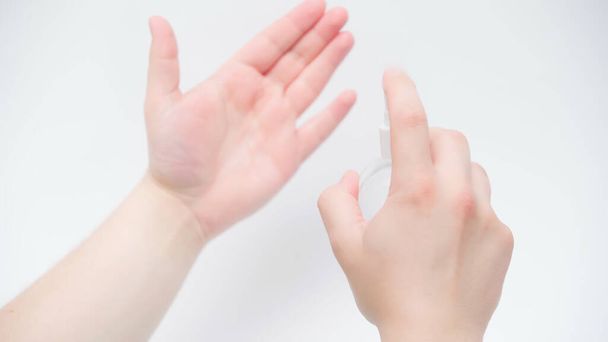 Καλλιεργημένη άποψη του ανθρώπου εφαρμογή απολυμαντικό χεριών σε λευκό φόντο - Φωτογραφία, εικόνα