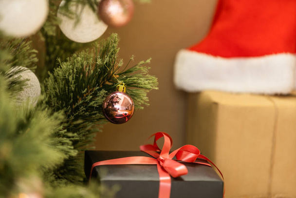 Рождественские подарочные коробки на полу возле елки в комнате - Фото, изображение