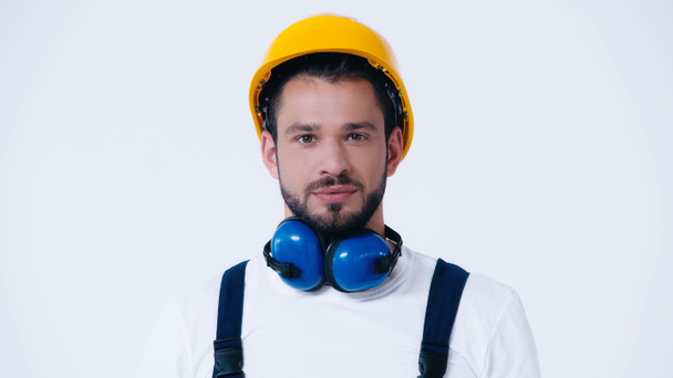 young foreman with hardhat and ear protection headphones looking at camera isolated on white - 写真・画像