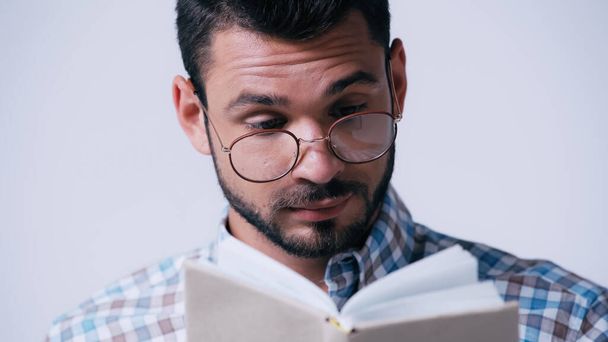 estudioso nerd reflexivo en gafas libro de lectura aislado en gris - Foto, imagen