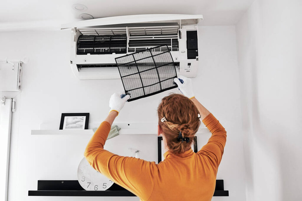 Mulher limpeza aircon filtros unidade interior em casa. - Foto, Imagem
