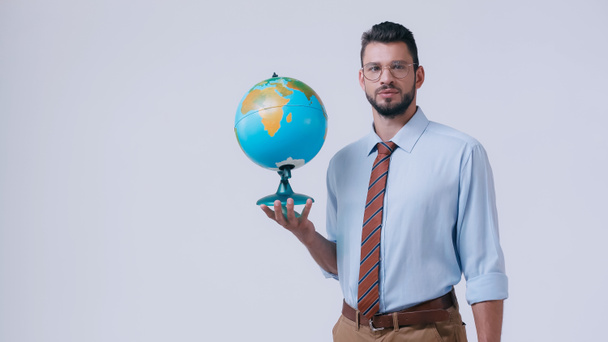 bärtiger Lehrer mit Brille, Globus in der Hand und Kamera isoliert auf grau - Foto, Bild