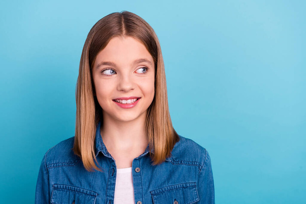 Photo of little blond girl look empty space wear jeans jacket isolated on blue color background. - Φωτογραφία, εικόνα