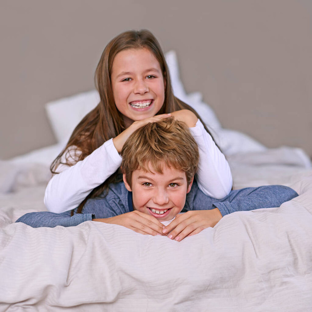 Los hermanos son los mejores amigos. Retrato de un hermano y una hermana acostados en una cama en casa - Foto, Imagen