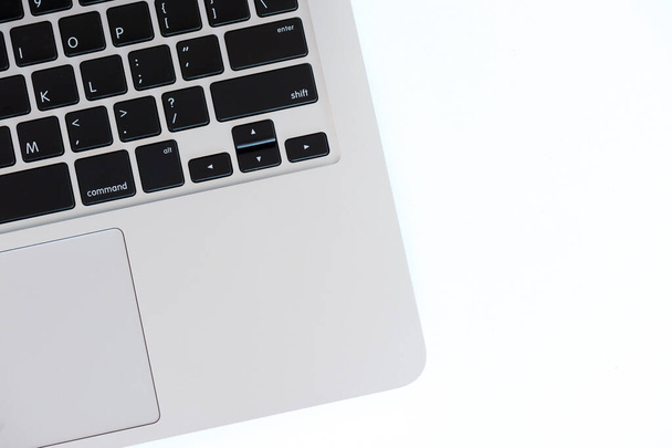 A laptop keyboard on a white wooden table. Top view - Zdjęcie, obraz
