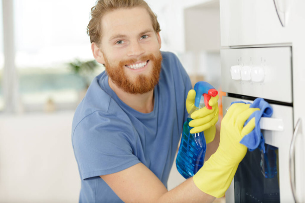 man cleaning domestic oven in kitchen - Foto, Imagen