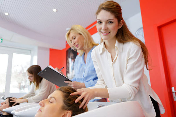 estagiário haidresser massagem clientes cabeça enquanto lavar o cabelo - Foto, Imagem