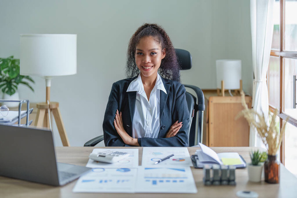 Портрет афро-американской предпринимательницы, которая улыбается, когда работает над увеличением прибыли своего бизнеса - Фото, изображение