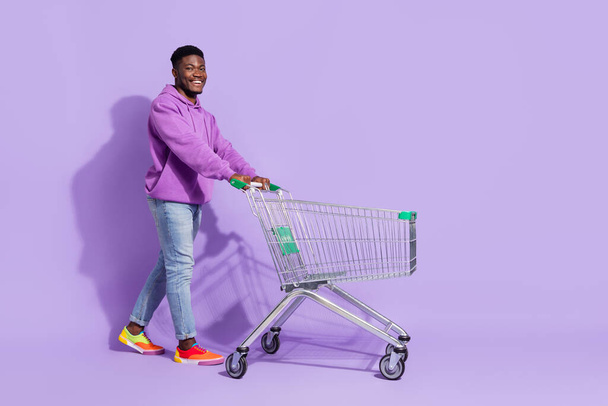 Full length body size view of attractive cheerful guy buying goods copy space isolated over bright violet lilac color background. - Фото, зображення