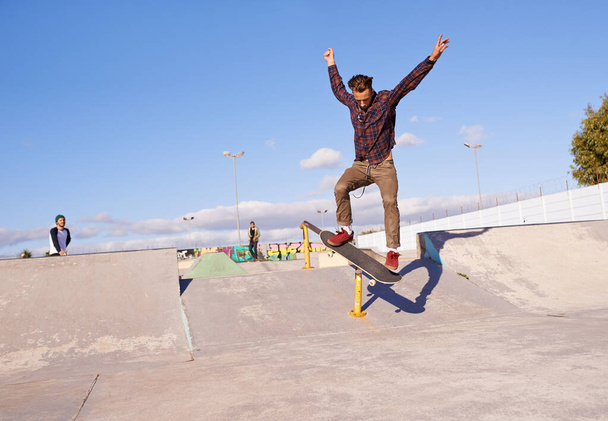 Haben Sie die Fähigkeiten auf diesem gesehen. Ein junger Mann trickst auf seinem Skateboard im Skatepark - Foto, Bild
