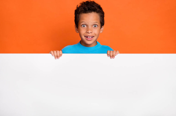 Photo portrait of cute small schoolboy impressed excited blank empty space dressed stylish blue outfit isolated on orange color background. - Foto, immagini