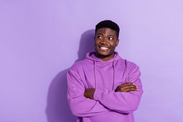 Portrait of positive cheerful man folded hands look interested empty space isolated on violet color background. - Zdjęcie, obraz