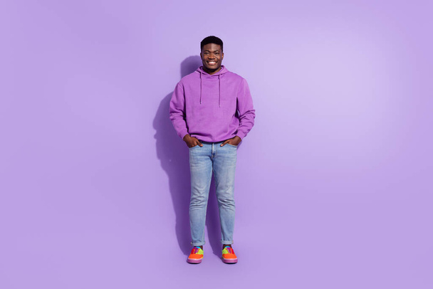Full size photo of satisfied young man hands pockets toothy smile isolated on purple color background. - Fotó, kép