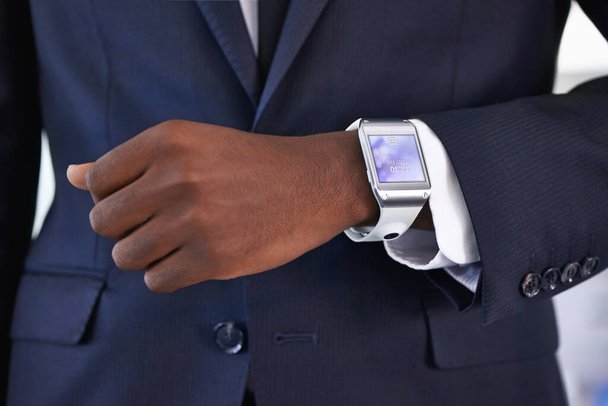 Utrzymanie czasu właśnie stało się hi-tech. Widok młodego biznesmena noszącego smartwatch - Wszystkie treści ekranu są zaprojektowane przez nas, a nie chronione prawem autorskim przez innych - Zdjęcie, obraz