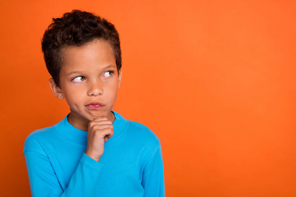 Photo of concentrated focused boy look empty space consider decision dilemma choice choose empty space isolated on orange color background. - Foto, Imagem