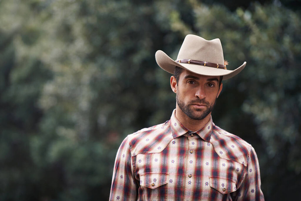 Style will never be plaid out. Portrait of a handsome man wearing a check shirt and cowboy hat - Foto, afbeelding