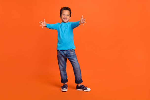 Full body photo of cute little boy stretching hands want cuddle friend parent wear trendy blue garment isolated on orange color background. - Valokuva, kuva