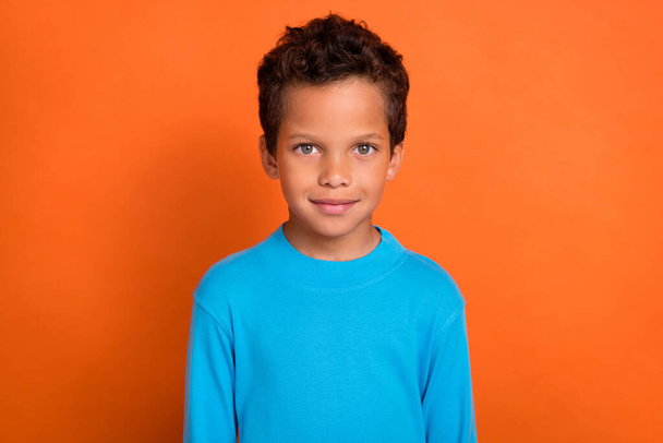 Photo of good nice looking boy dressed blue fashionable jumper look camera isolated on orange color background. - Foto, afbeelding
