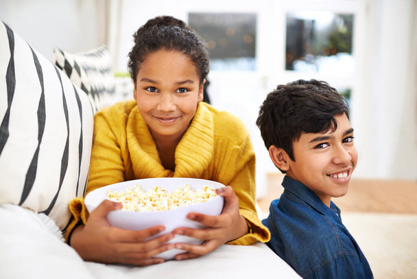 Ready for the movie. ethnic siblings holding a bowl of popcorn - Fotografie, Obrázek