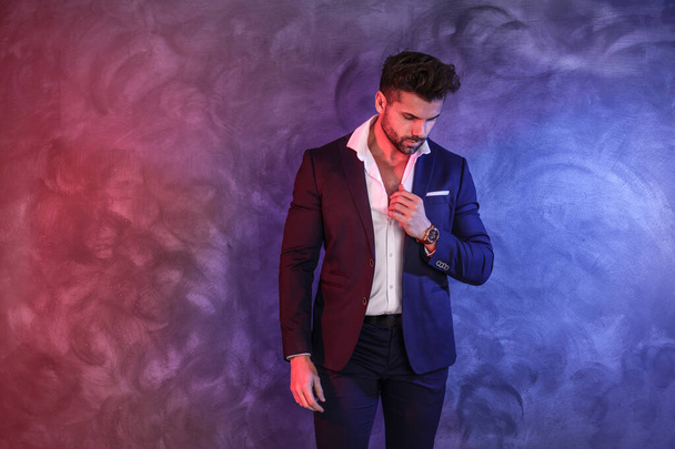 Handsome, confident, elegant man posing in fashionable suit, wearing luxury hand watch. Copy space. Male model. - Фото, зображення