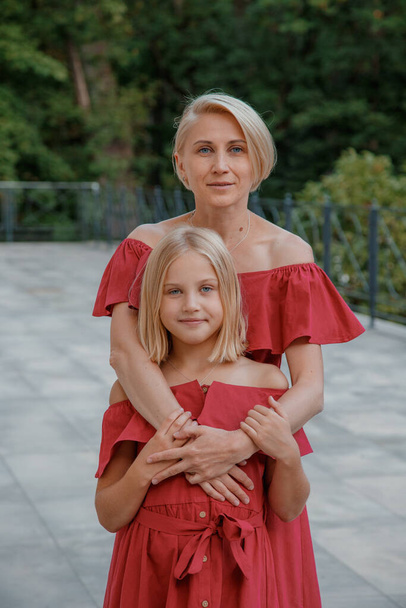 Close up portrait of mother and daughter hugging. Portrait of cheerful mother and daughter. Happy family blonde mother and daughter. - Foto, afbeelding